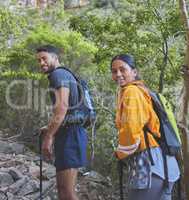 Walking sticks are so helping with tougher terrain. a young couple hiking on a mountain range outdoors.