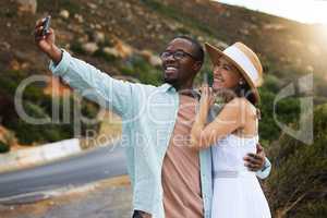 The more we travel the more memories we gain. a happy young couple taking selfies on a road trip.