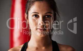 Fit anf confident. Cropped portrait of an attractive young female boxer training in the gym.