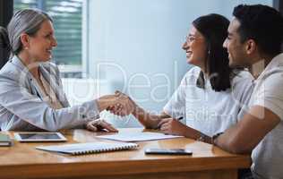 Our glass house will throw rocks at all it pass. a young couple sharing a handshake with a consultant theyre meeting to discuss paperwork an office.