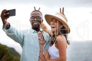 Make the good times last a long time. a happy young couple taking selfies on a road trip along the coast.