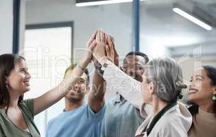 Our aim is to win this together. a group of businesspeople giving each other a high five in an office.