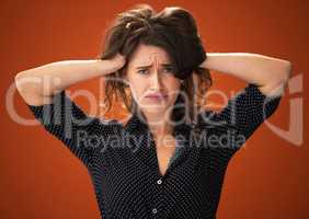 Send help. an attractive young woman standing alone against a red background in the studio and touching her hair.