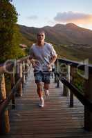 Time to get those endorphins going. a young man running alone outside.