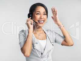Customer service so good it defies all logic. Studio shot of a confident young businesswoman using a headset against a grey background.