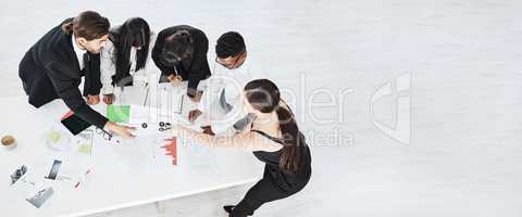 Taking the day to complete their reports. High angle shot of a group of businesspeople brainstorming together in an office.