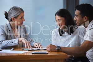 The timings poor, its never right, do it. a young couple meeting with a consultant to discuss paperwork an office.