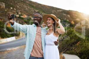 We went looking for adventure and found heaven. a happy young couple taking selfies on a road trip.