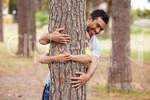 Body of the world, there is soul, you are that. a young man and a boy hugging a tree in the woods.