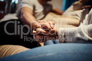 I never want to let go. a young couple holding hands while sitting together at home.