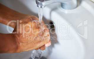 Making health a priority, one wash at time. an unrecognizable male washing his hands in a hand basin at home.