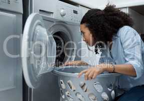 Fresh laundry always smells so good. a young woman preparing to wash a load of laundry at home.