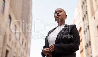I have a goal and Im going to get to it. Low angle shot of a young businesswoman looking thoughtful while standing in the city.