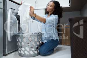 This washing powder really makes clothes sparkle. a young woman preparing to wash a load of laundry at home.