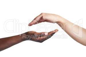 Whatever brings you together is worth it. Cropped studio shot of two women reaching their hands out to each other against a white background.