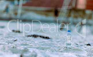 Heal the planet by recycling one bottle at a time. a bottle laying on the beach.