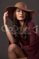 Sleek and sophisticated. Cropped portrait of an attractive young woman posing in studio against a grey background.