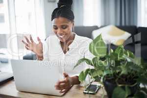 Thanks for hosting todays video chat. an attractive young businesswoman sitting alone and using her laptop to work from home.