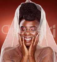 Happiness makes her even more beautiful. an attractive young woman posing with her eyes closed in studio against a red background.