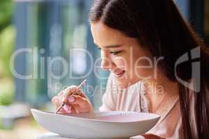 Im looking forward to hosting a dinner party to show this off. a young woman painting ceramics in an art studio.