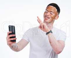 Im not different, Im limited edition. Portrait shot of a handsome young man with vitiligo taking a selfie with a mobile phone on a white background.