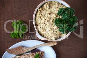 Eating well is a form of self respect. Overhead shot of a cauliflower pt in a ceramic serving dish accompanied with seed crackers on a wooden table.