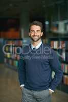 I work best in libraries. Cropped portrait of a handsome young businessman standing with his hands in his pockets in an empty library.