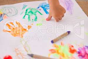 Painting provides lots of opportunities to learn. an unrecognizable little girl doing a handprint art.
