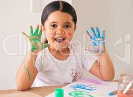 This is so much fun. an adorable little girl sitting at home with water-based paint smeared on her hands.