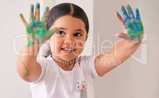 Who needs paper. an adorable little girl sitting at home with water based-paint smeared on her hands.