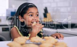 Mom really is the best baker. a little girl helping herself to freshly made cookies at home.