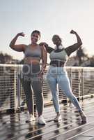 Do more of what makes you feel more confident. two young women flexing while out for a run.