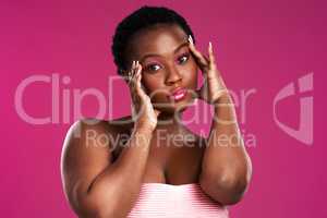 Can you guess what Im thinking. Studio shot of a beautiful young woman posing against a pink background.