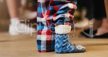 Nothing says Christmas like cosy character socks for kids. an unrecognisable little boy wearing cute fluffy character socks during a Christmas party with family at home.