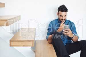 Male texting on a phone, browsing social media online while sitting on steps. Surfing the internet, Sharing information, networking and staying connected. Updating status and posting feed with an app