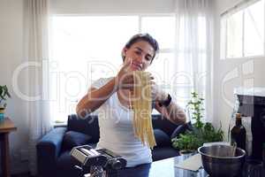 Cooking is her passion. an attractive young woman cooking homemade pasta at home.