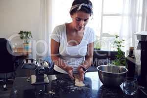 Attention to detail is key. an attractive young woman cooking homemade pasta at home.
