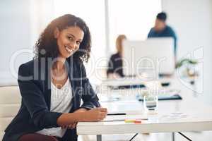 Happy corporate business woman working at her desk, doing admin and taking notes while in an office at work. Portrait of a cheerful, joyful and professional female writing in a notebook at a table