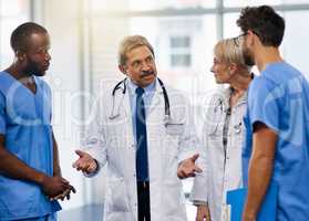 Doctors talk, brainstorm and plan together to collaborate and discuss medical procedures in a hospital. Health professional colleagues consult and working together in a meeting while sharing ideas