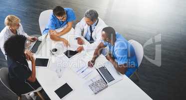 Team of medical workers sitting and meeting with laptops around table. Doctors and staff discussing papers and test results. Healthcare experts handling daily tasks and duties