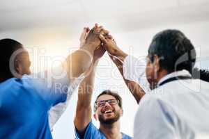 Happy doctors, medical professionals and team giving high five in celebration of success, wining and achievement at a hospital. Group of health experts showing support, teamwork and excitement