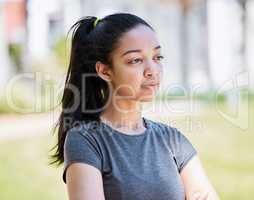 Maybe I should switch up my running routine. a young woman looking thoughtful during her workout at the park.