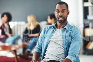 Casual, cool and trendy businessman, marketing manager or entrepreneur at a team informal brainstorming meeting. Face portrait of a young and stylish man at a gathering with colleagues in background