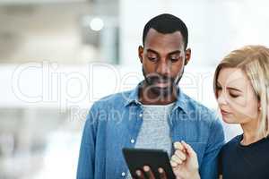 Business people talking together while checking information, data or statistics on a tablet. Employee asking manager, supervisor or boss for help with a problem, project or idea while standing inside