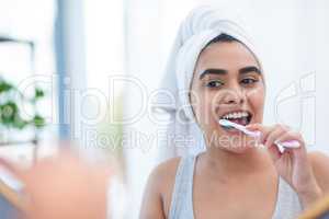 I should have invested in this toothbrush ages ago. a beautiful young woman brushing her teeth in the morning.