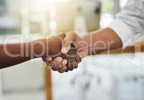 A team handshake in agreement between colleagues and coworkers in an office. Working together as a team to achieve success, merge as a partnership or promote a business person at work closeup