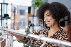 Looks like she found quite a bargain. a young woman shopping for clothes in a store.