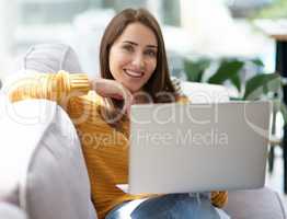 With uncapped wifi, home has become my ultimate happy place. Portrait of a young woman using a laptop while relaxing on a sofa at home.