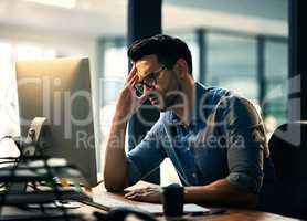 Is the week over yet. Shot of a young businessman experiencing stress during a late night at work.