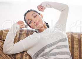 Slow it down and soak it up. a young woman relaxing on the sofa at home.